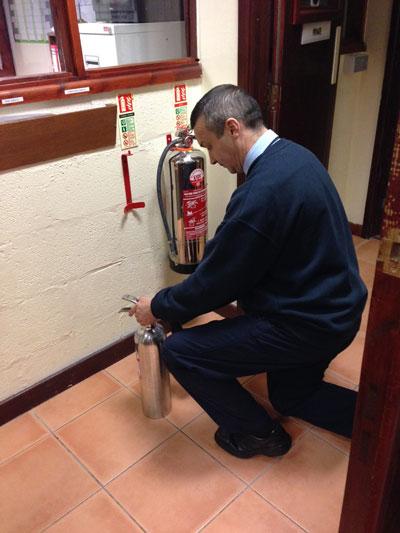 Fire Technician Carrying Out Fire Extinguisher Servicing